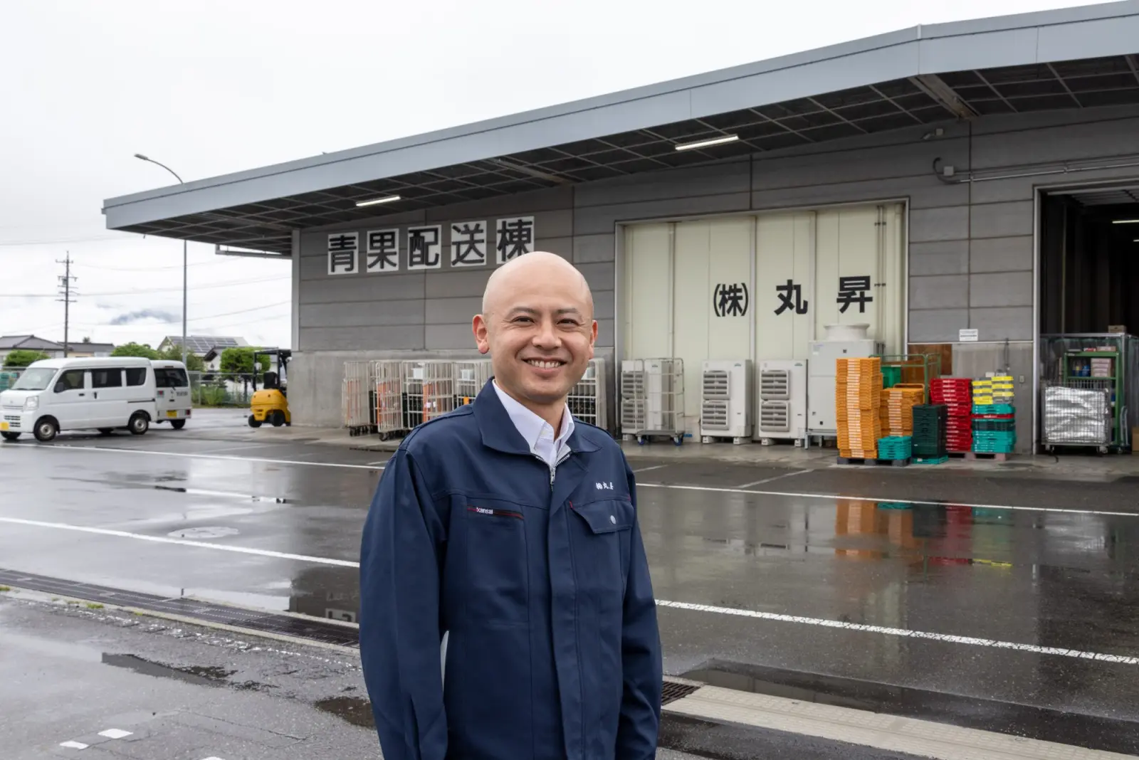 青果配送棟の前で笑顔を見せる代表取締役社長・中島康喜